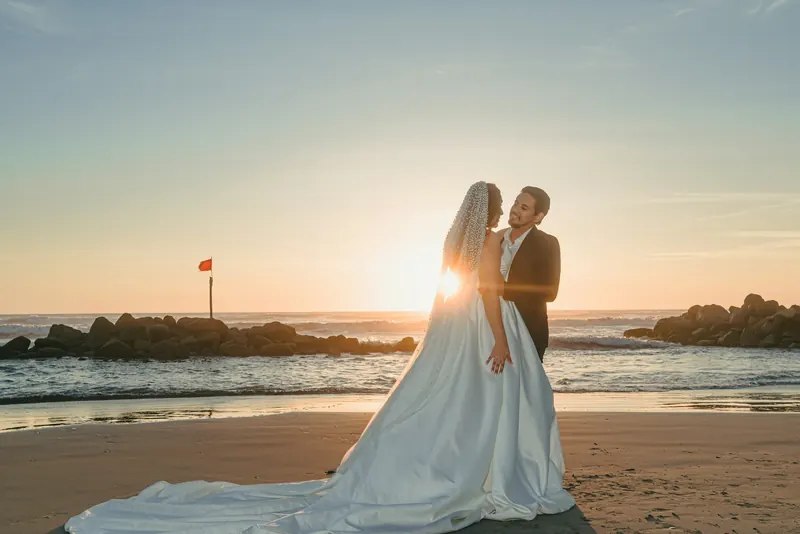 An illustrative photograph of a couple together by the sea at sunset